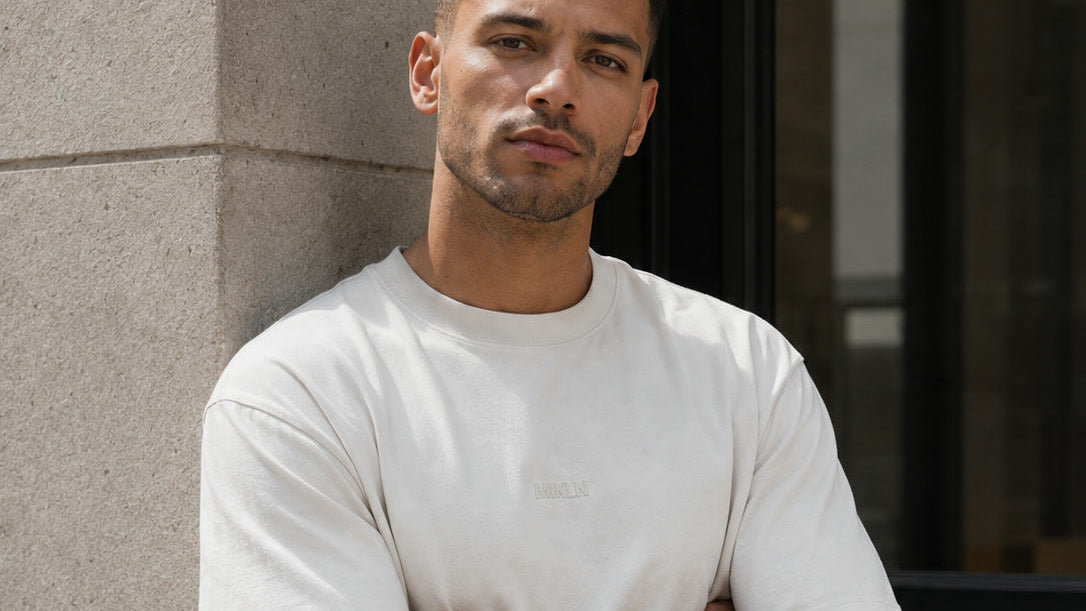 Relaxed fit T-shirt in off-white, gedragen met de armen over elkaar