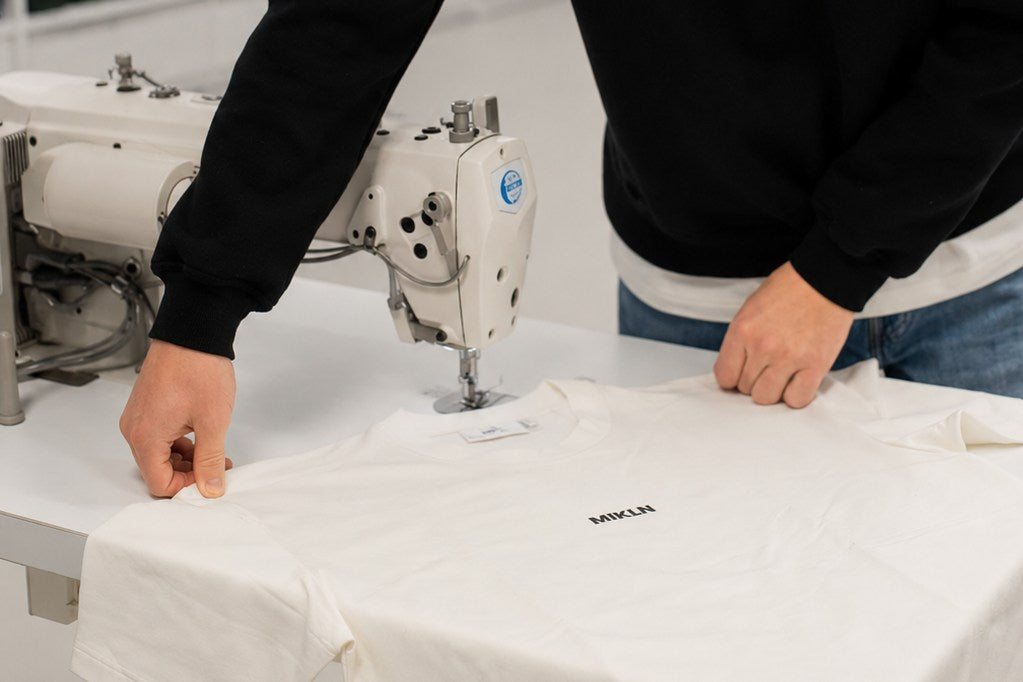 Een MIKLN-shirt wordt met de hand gemaakt aan de naaimachine in het atelier