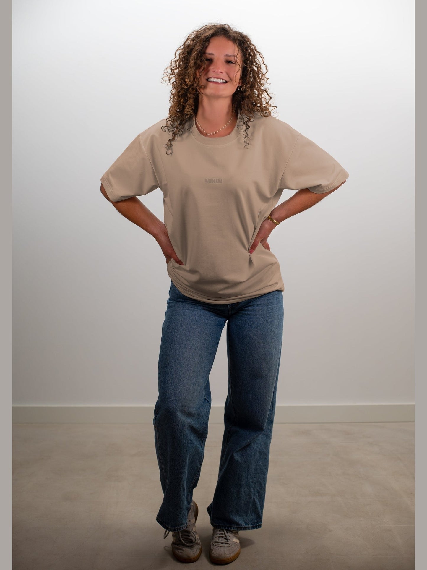 vrouw draagt het mikln original t-shirt in beige met relaxed fit