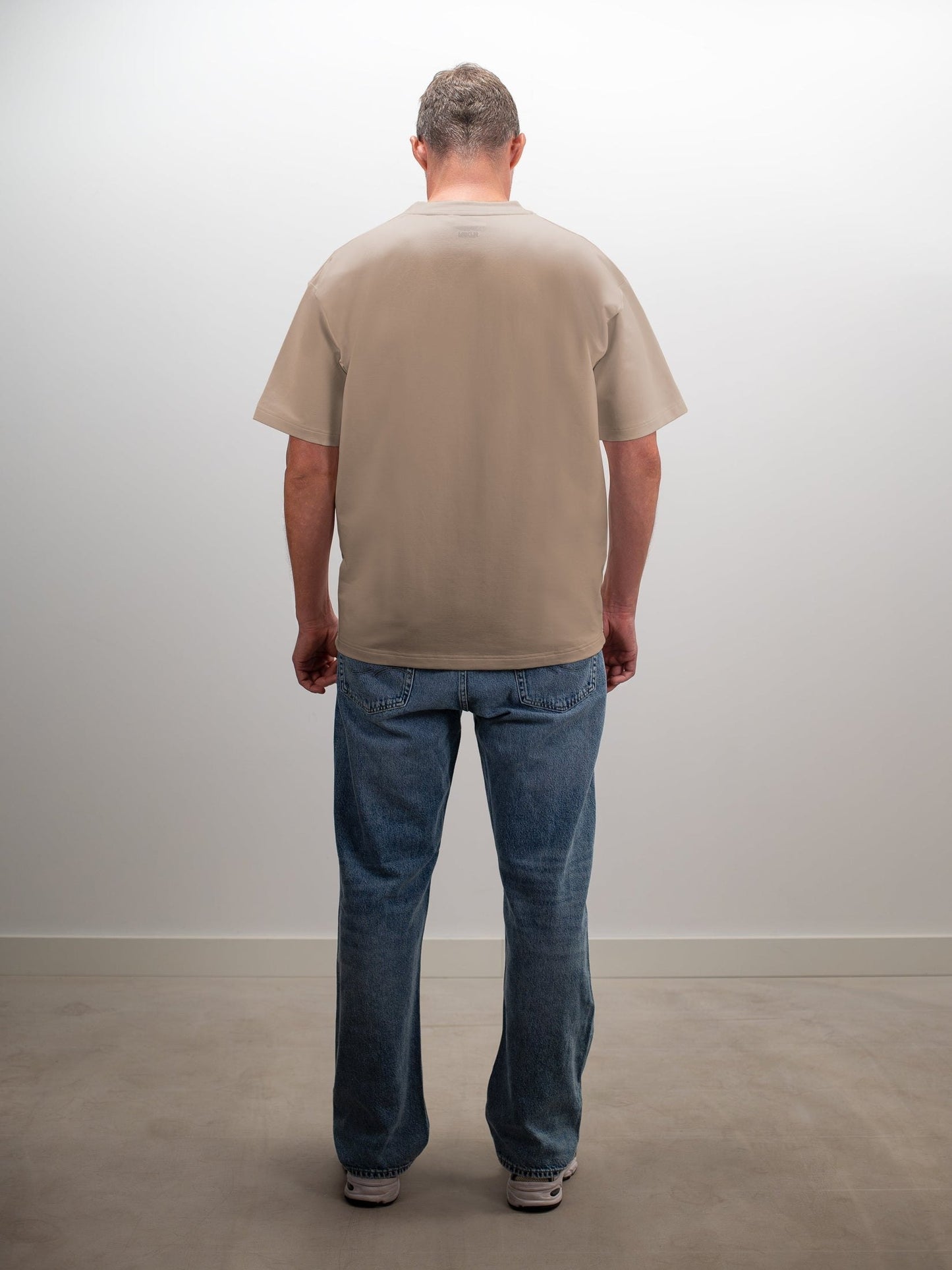 man draagt het mikln original t-shirt in beige, achterkant