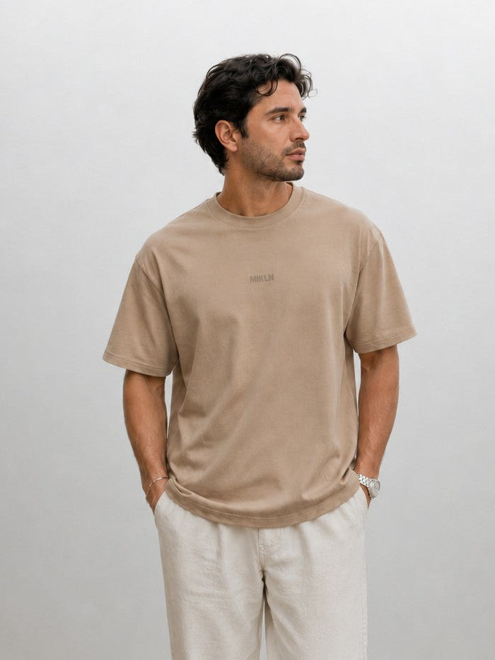model draagt het mikln original t-shirt in beige met ton-sur-ton logo, relaxed fit