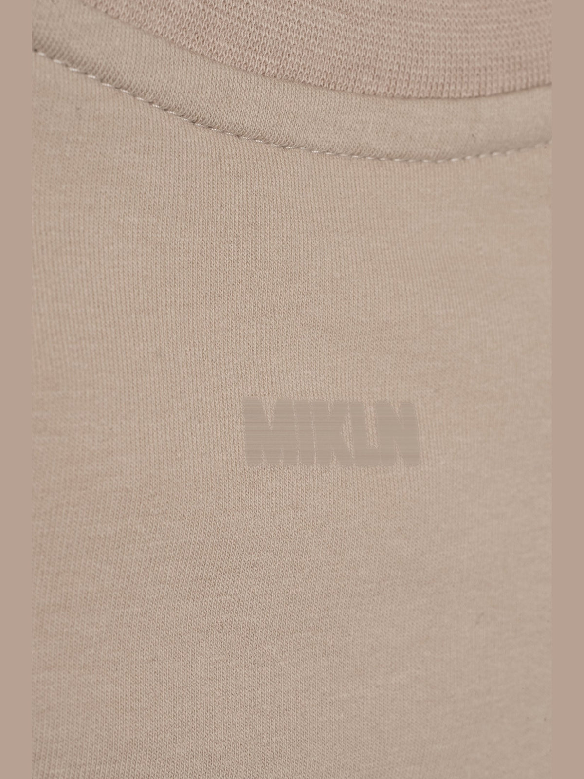 MIKLN T 03 beige long sleeve close-up van het ton-sur-ton logo op de borst