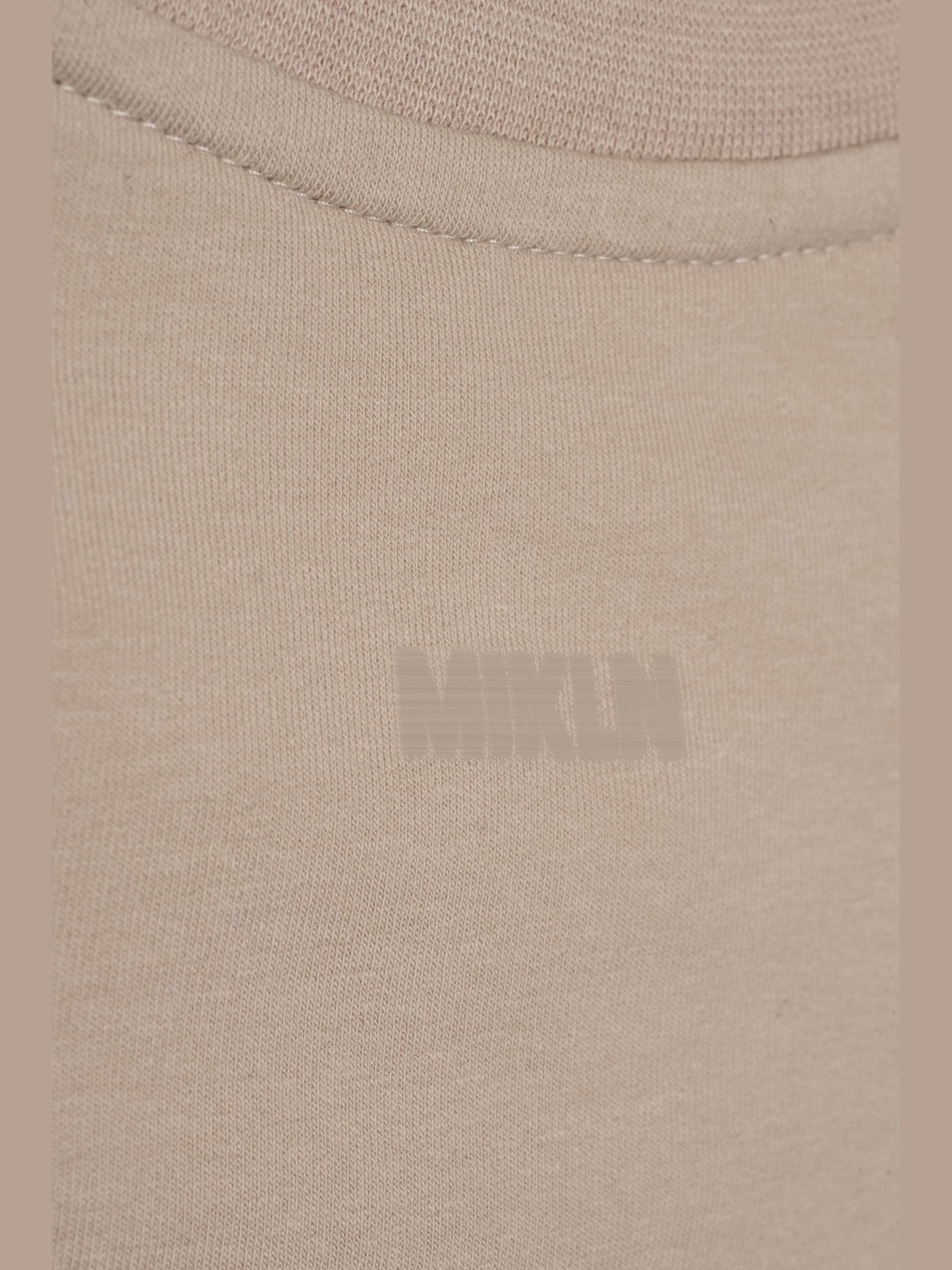 MIKLN T 02 beige close-up van het logo op de stof