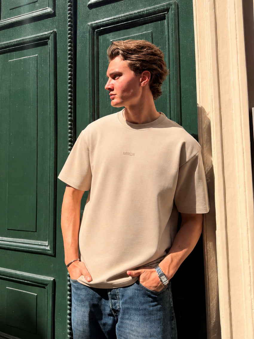 MIKLN T 02 beige T-shirt gedragen op straat in Amsterdam, ton-sur-ton logo