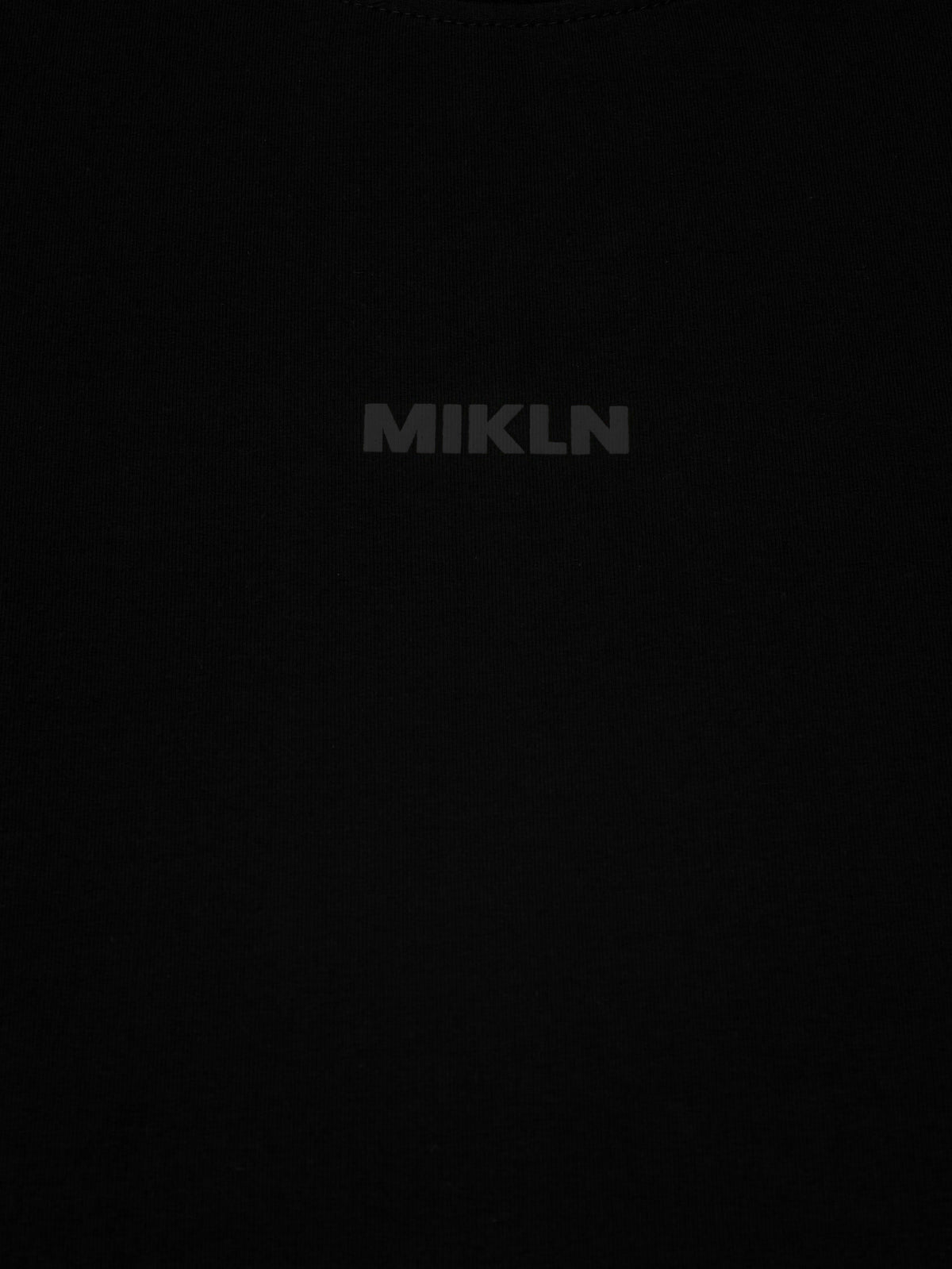 MIKLN T 02 zwart detail van het logo en de stofstructuur