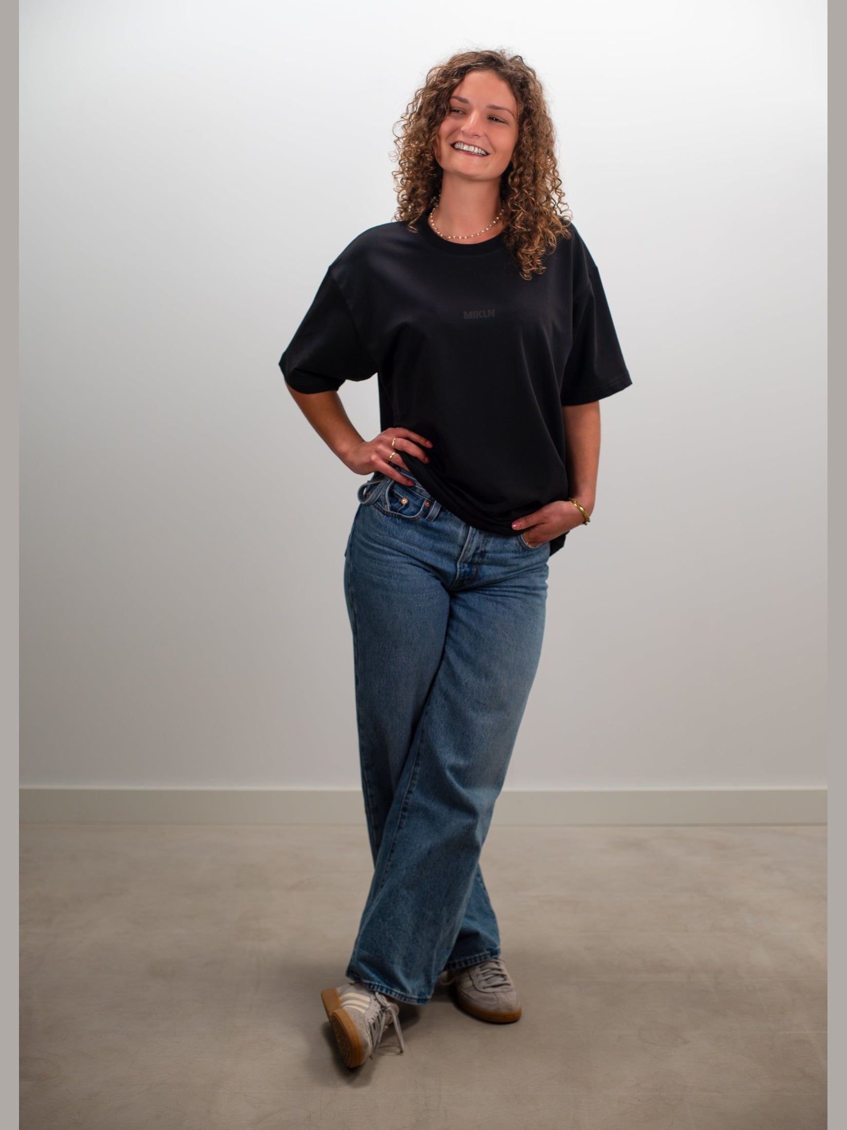Vrouw draagt het MIKLN Original T-shirt in zwart met relaxed fit