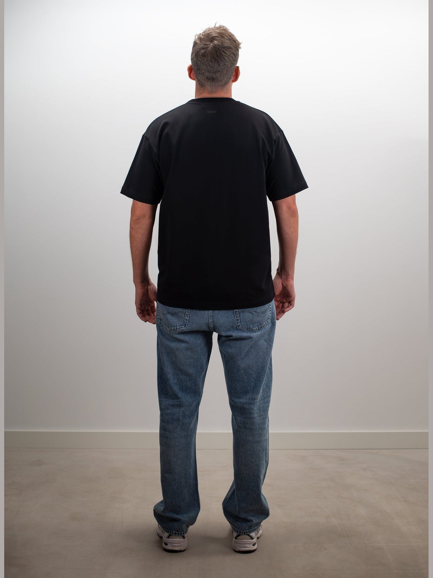 man draagt het mikln original t-shirt in zwart, achterkant