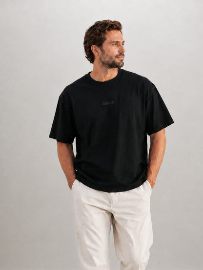 Man draagt het MIKLN Original T-shirt in zwart met relaxed fit