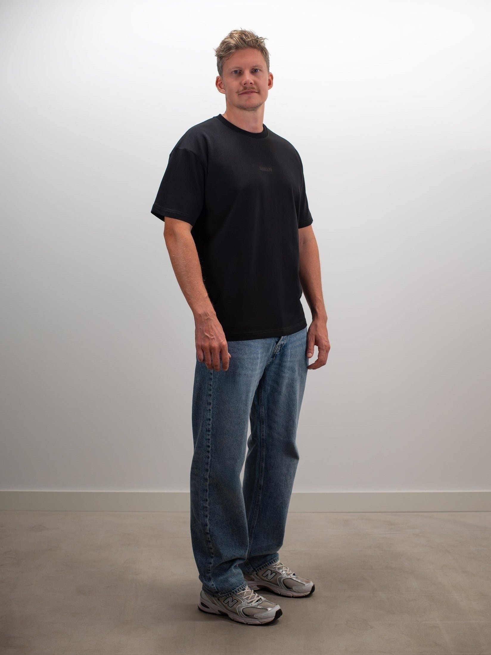 Man draagt het MIKLN Original T-shirt in zwart met relaxed fit