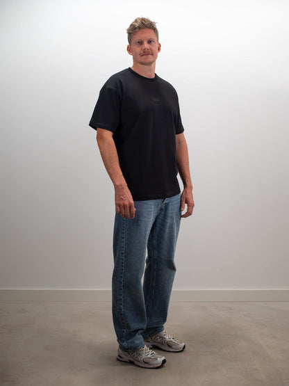 Man draagt het MIKLN Original T-shirt in zwart met relaxed fit