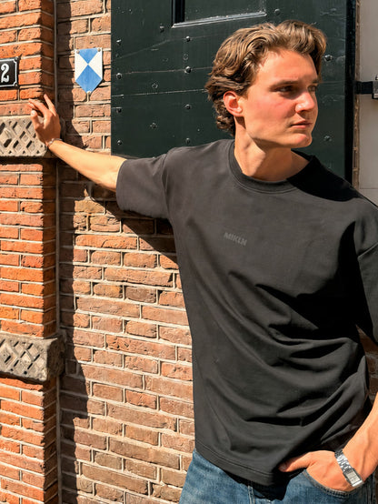 MIKLN T 02 zwart T-shirt gedragen op straat in Amsterdam, ton-sur-ton logo