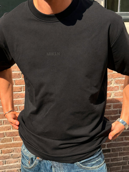 MIKLN T 02 zwart T-shirt close-up pasvorm met MIKLN logo, gedragen op straat