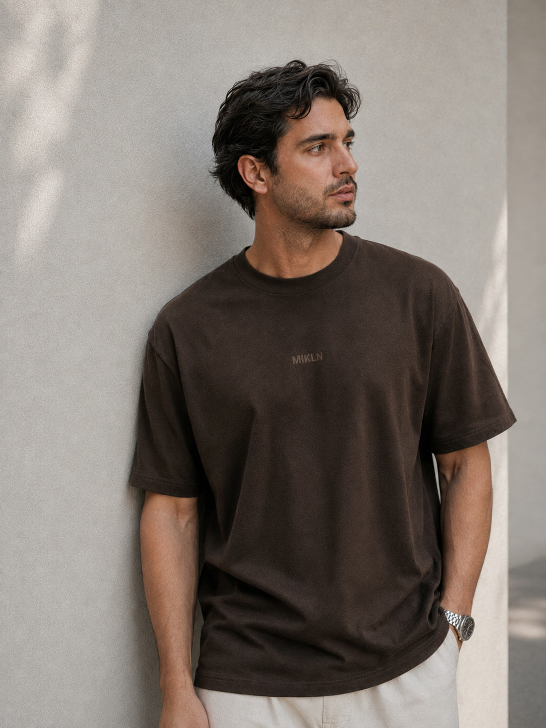 MIKLN T 02 bruin T-shirt gedragen tegen een lichte muur, relaxed fit