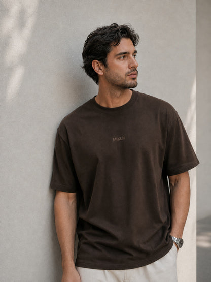 MIKLN T 02 bruin T-shirt gedragen tegen een lichte muur, relaxed fit
