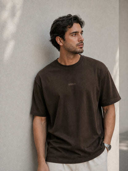 MIKLN T 02 bruin T-shirt gedragen tegen een lichte muur, relaxed fit
