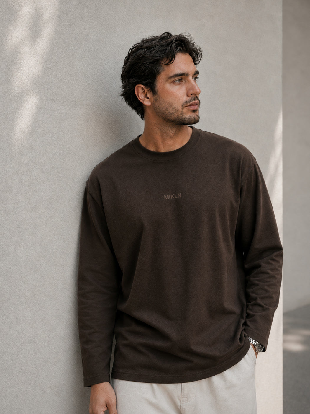 MIKLN T 03 bruine long sleeve gedragen tegen een lichte muur, relaxed fit