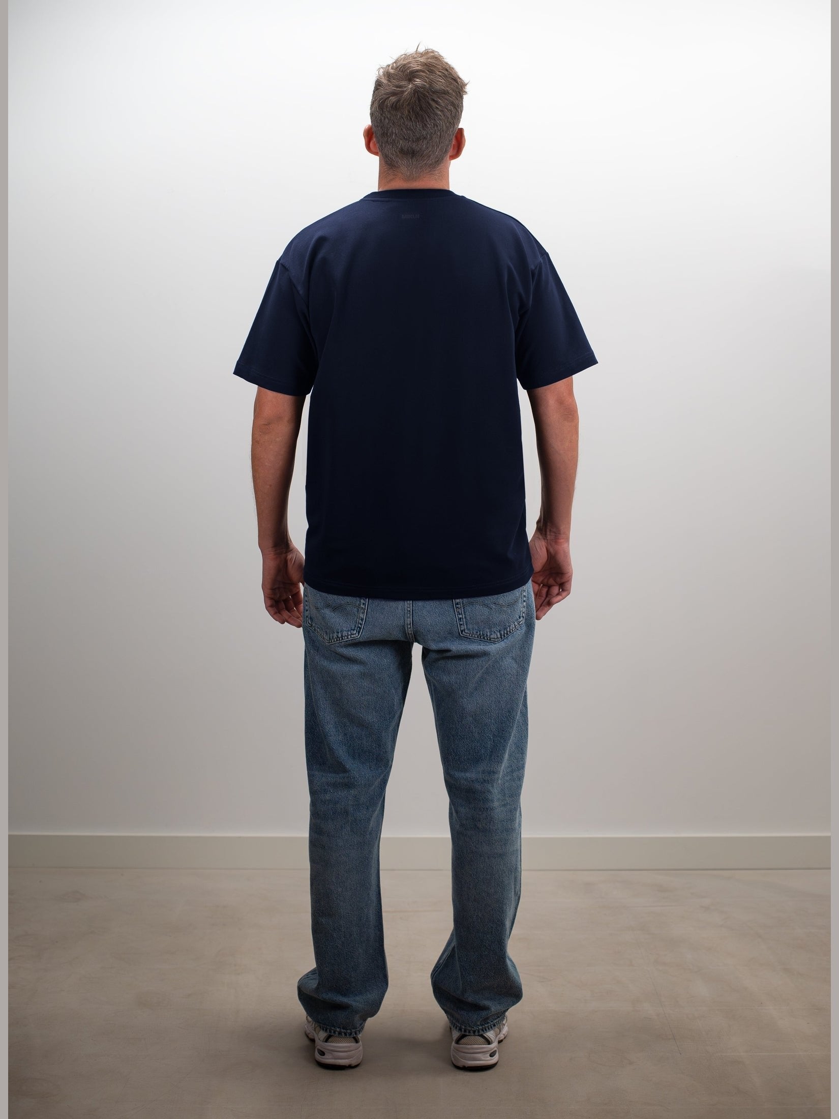 Man draagt het MIKLN Original T-shirt in blauw, achterkant