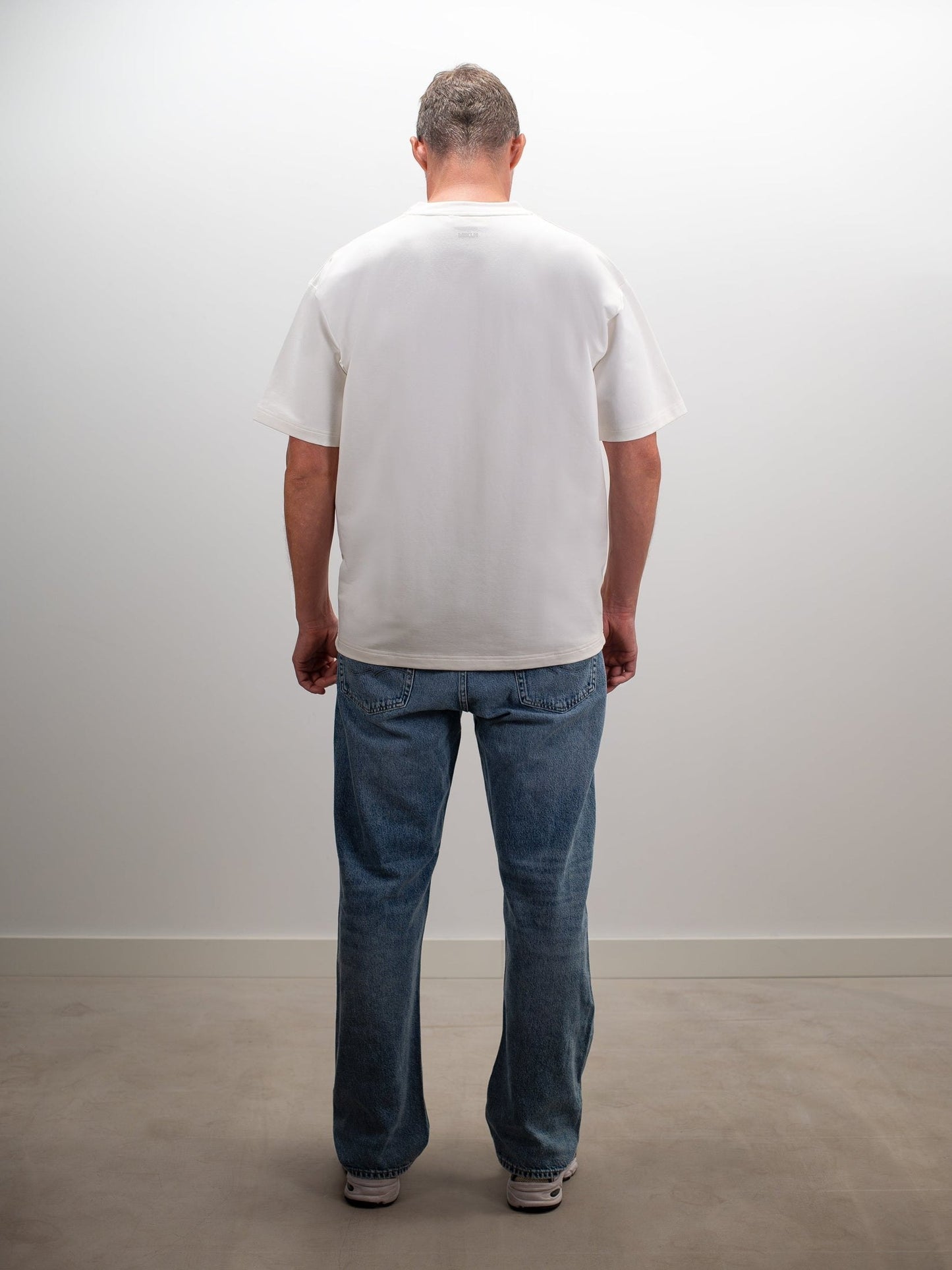 man draagt het mikln original t-shirt in off-white, achterkant