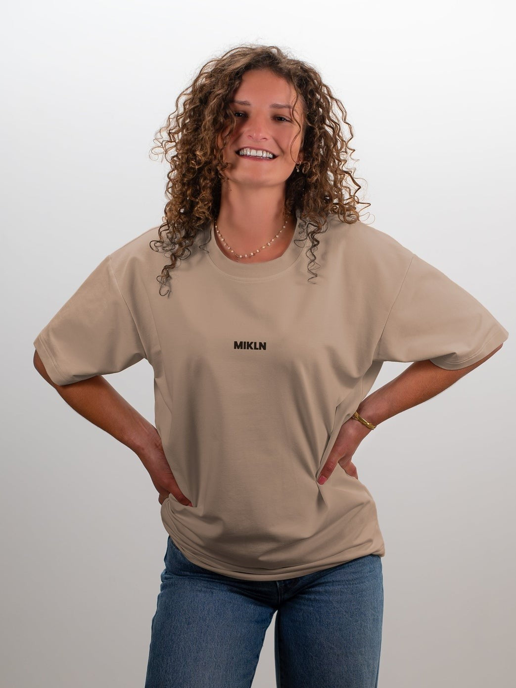 Vrouw draagt het MIKLN Original T-shirt in beige met relaxed fit