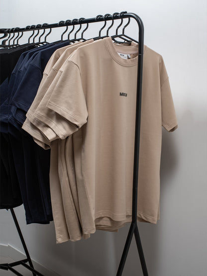 Kledingrek met MIKLN T-shirts in beige en navy in het atelier