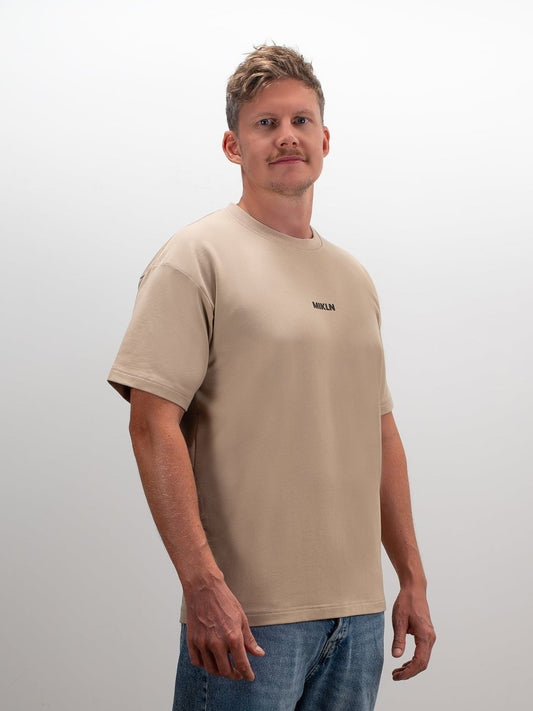 Model draagt het MIKLN Original T-shirt in beige, casual gedragen