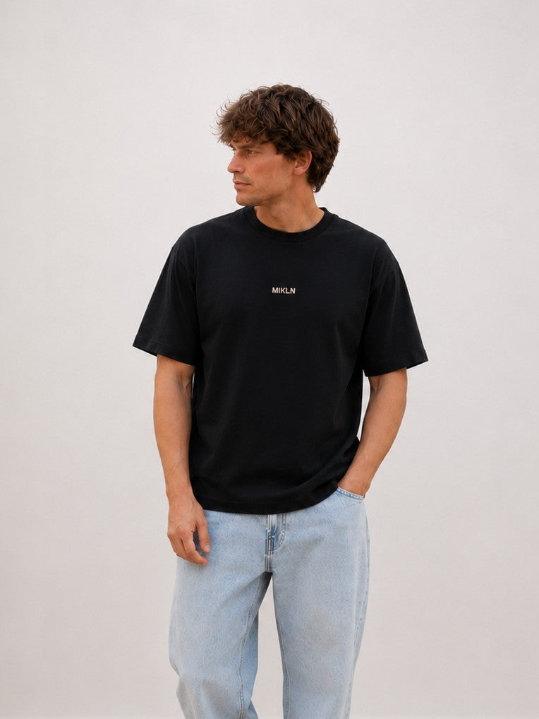 Man draagt het MIKLN Original T-shirt in zwart met relaxed fit